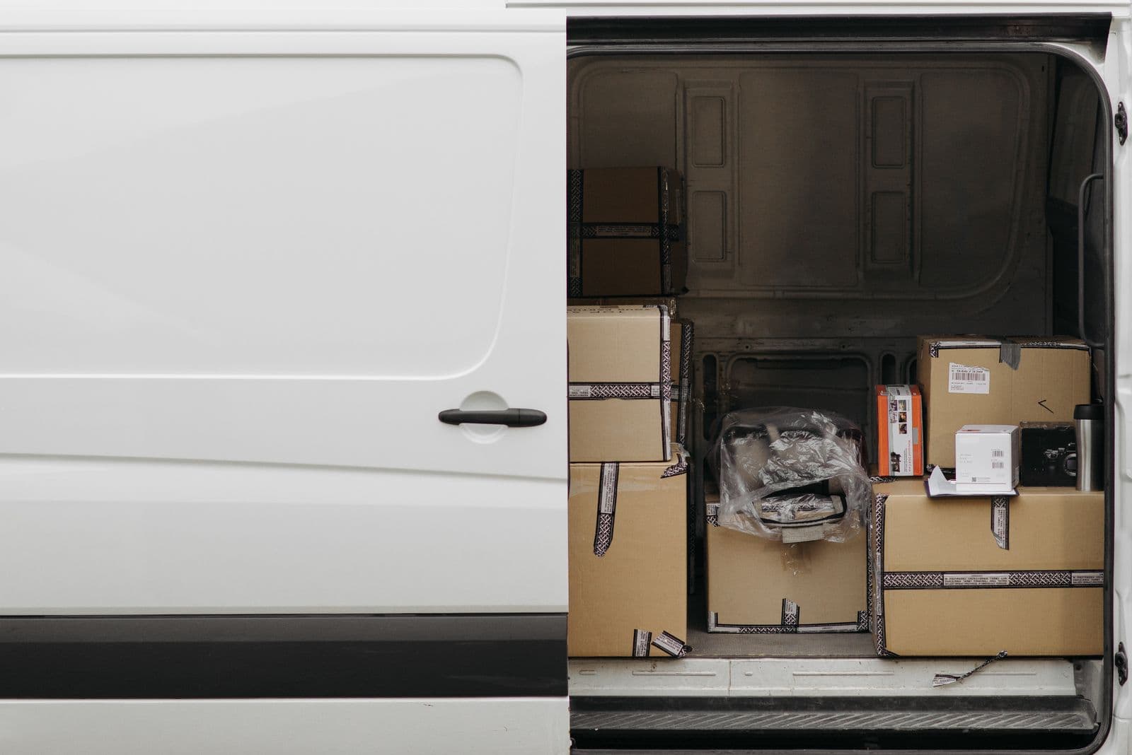 Open side door of a delivery van loaded with parcels ready for collection